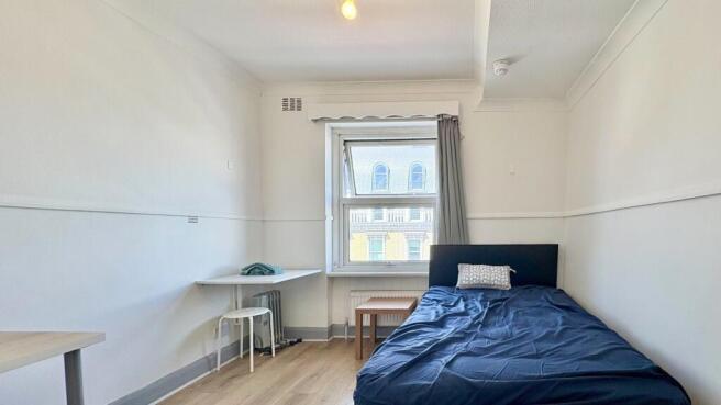 Bright and tidy bedroom with a workspace area....