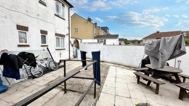 Spacious paved garden with social seating area...