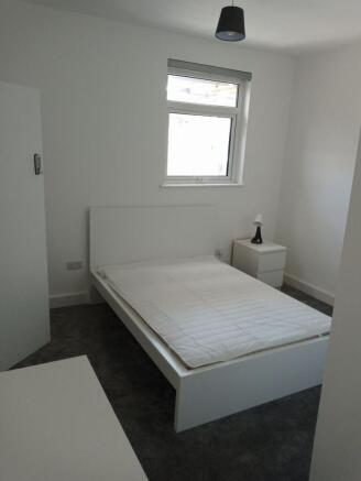Sleek modern bedroom with plush grey carpet...