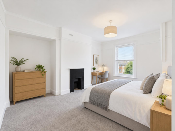 Bright rental bedroom with period fireplace.png