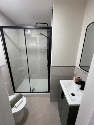 Contemporary bathroom with a glass-framed showe...