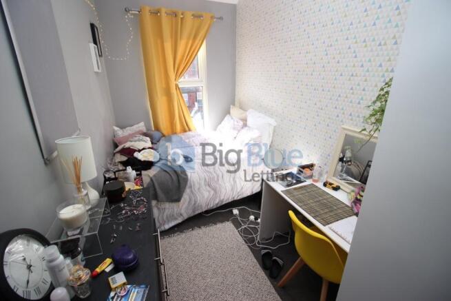 A compact and functional bedroom featuring a si...