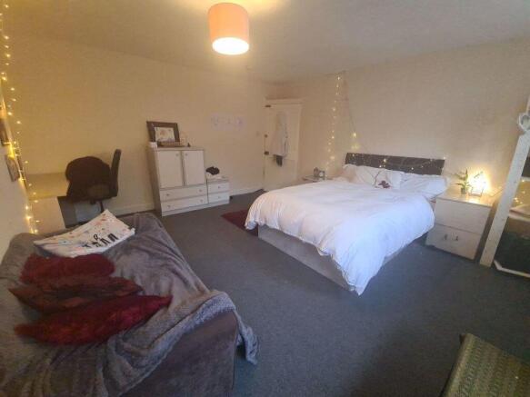 A spacious and well-lit master bedroom featurin...