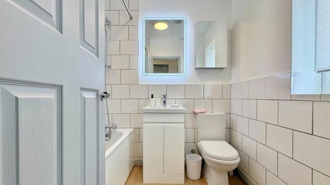 Modern bathroom suite with illuminated mirror...