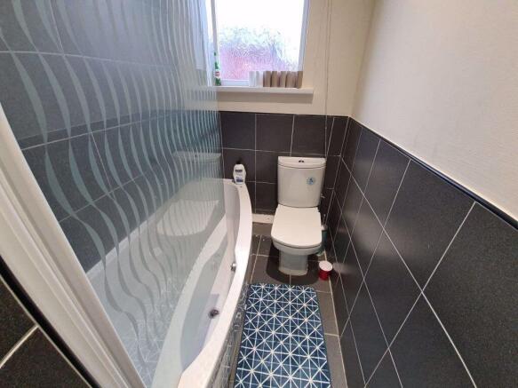 A modern bathroom suite featuring a curved bath...