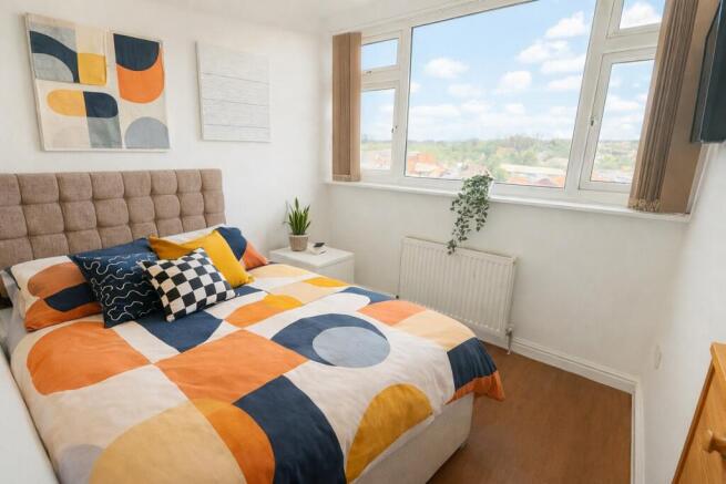 Bright double bedroom with colourful bedding an...