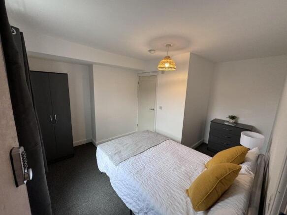 A cozy double bedroom featuring a neatly made b...