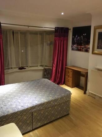 Bright bedroom with a large double bed, bay win...