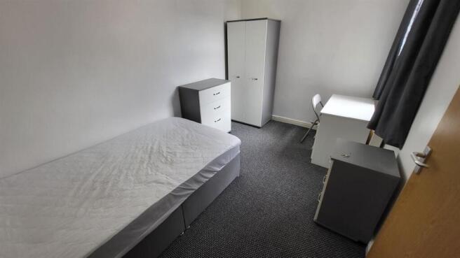 Bright, simply furnished single bedroom with a ...