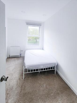 Bright, simply furnished bedroom with a double ...