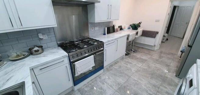 Bright modern kitchen with marble-effect surfac...