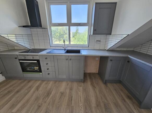 Modern galley-style kitchen with grey cabinetry...
