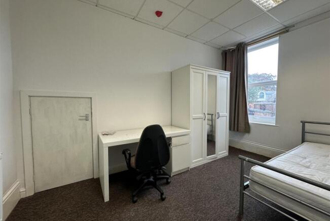 Bright, simply furnished bedroom with large win...