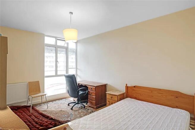 Bright bedroom with large window and study desk...