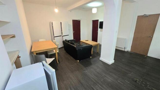 Open-plan living area with dark wood-effect flo...