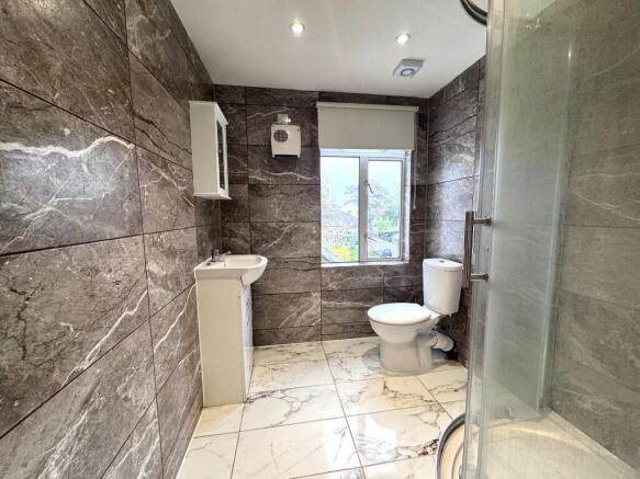 Modern tiled bathroom with shower and window...