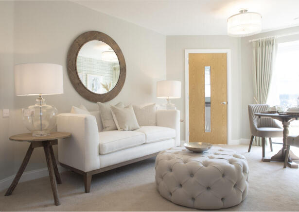a living room with a white couch and a round mirror