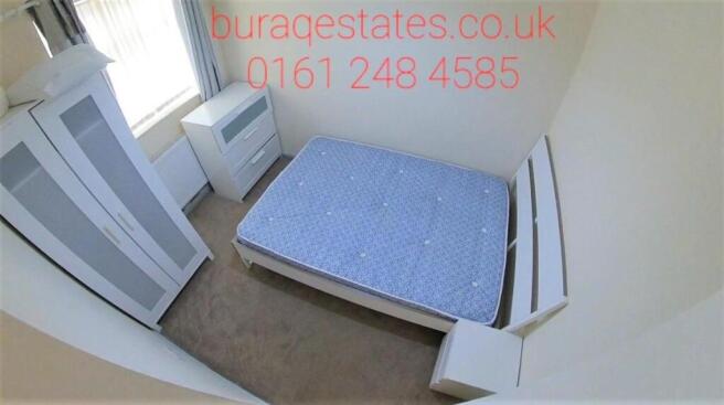 Bright, simply furnished bedroom with a double ...