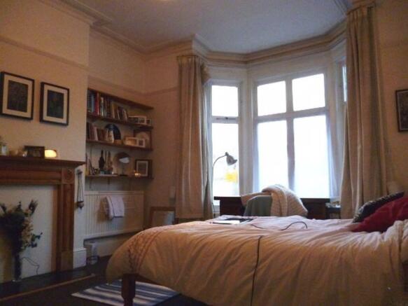 A cozy bedroom featuring a large window allowin...