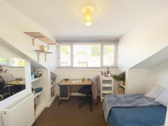 Bright furnished bedroom with a single bed, bui...