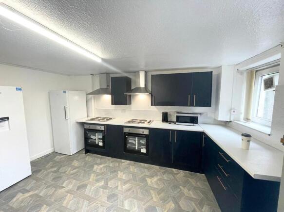 Modern kitchen with sleek units and dual ovens...