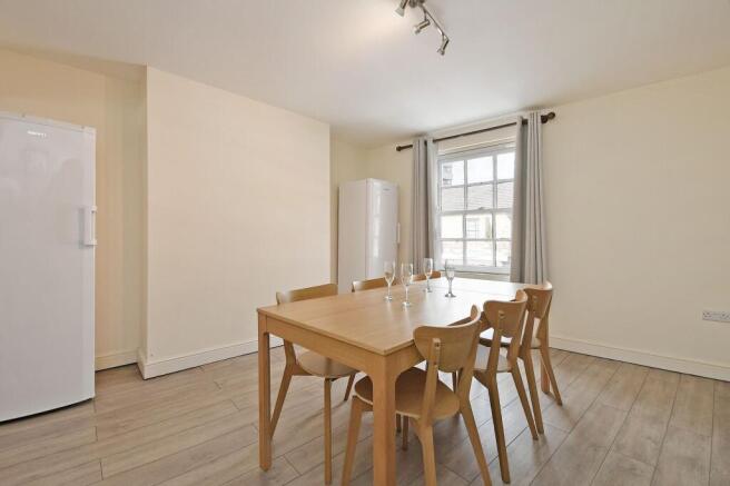 Bright, neutral dining area with a large sash w...