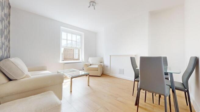Bright and airy living room featuring light woo...