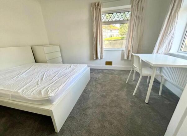 A bright and spacious double bedroom with a mod...