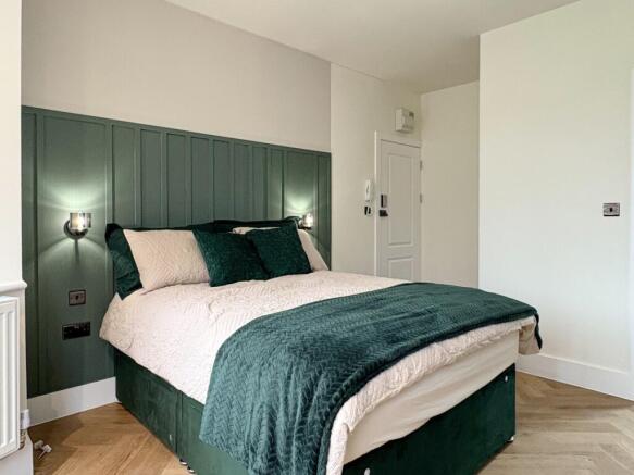 Bright, stylish double bedroom with a paneled f...