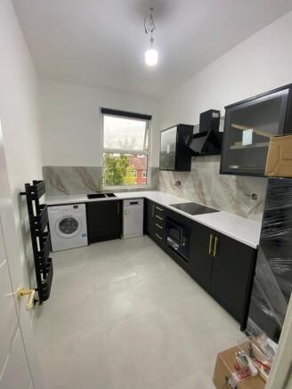 Modern, well-lit kitchen featuring sleek black ...
