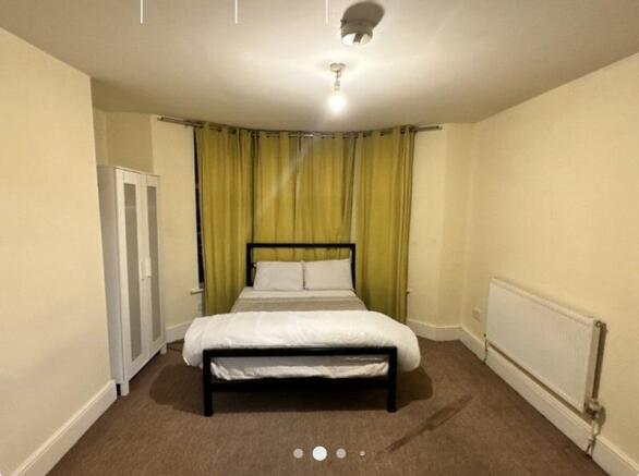 A clean, simply furnished double bedroom featur...