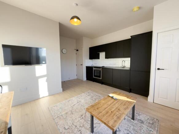 Modern open-plan kitchen with sleek dark units...