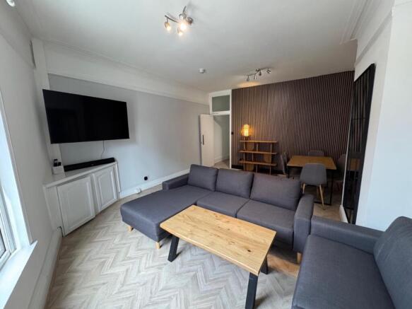 Bright, spacious living room with large wall TV...