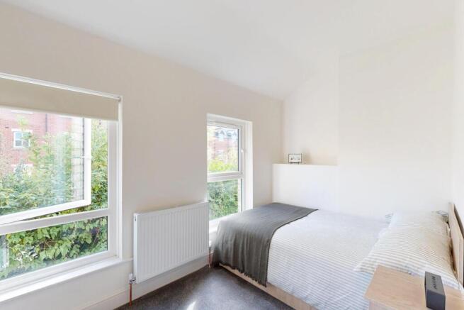 Bright and airy bedroom featuring a large doubl...