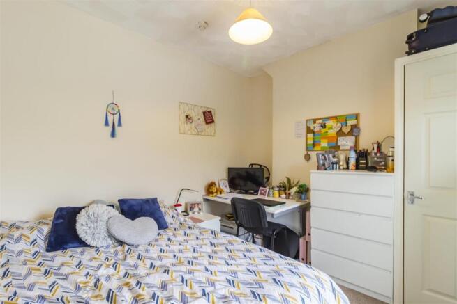 Bright bedroom with ample study space and stora...