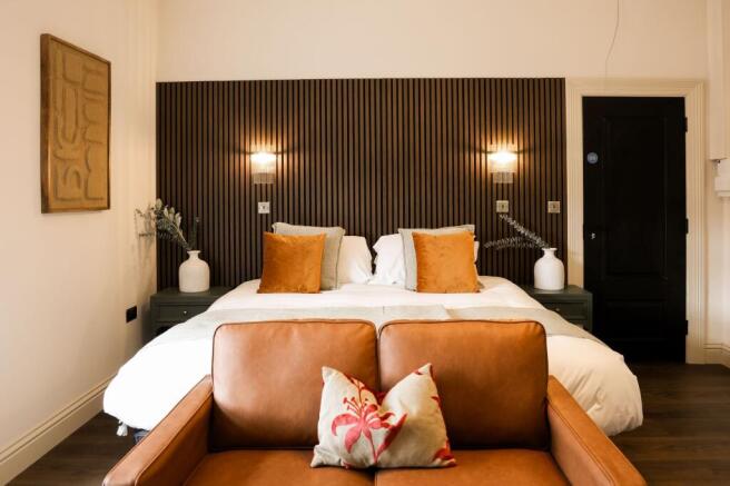 Stylish bedroom with feature wall and plush sof...
