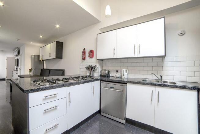 Modern galley-style kitchen with white cabinets...