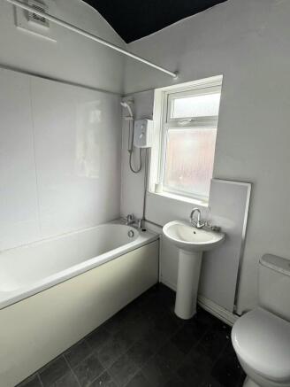Bright bathroom featuring a full bathtub and wi...