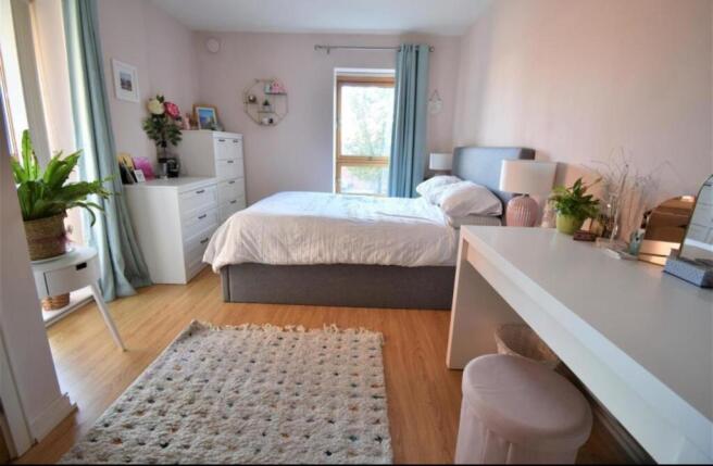 Bright, spacious bedroom with desk and natural ...