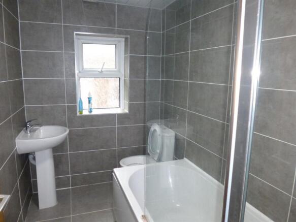 Modern tiled bathroom with a bath, shower enclo...