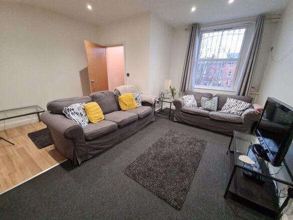 A spacious, well-lit living room featuring comf...