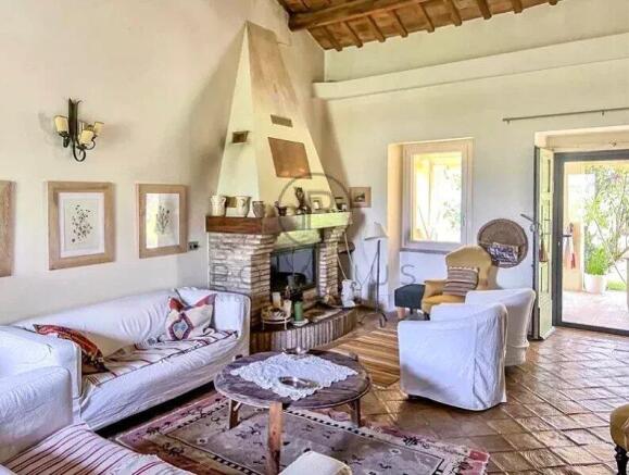 Cozy living room with white sofas, a brick firepla