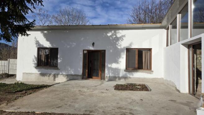 Main entrance area featuring a glass door and two windows on white walls