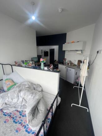 A cozy single bedroom with a comfortable bed, a...