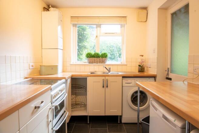 Bright galley-style kitchen with wooden worktop...
