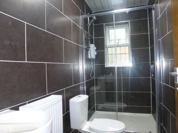 Modern tiled bathroom with a walk-in shower, wh...