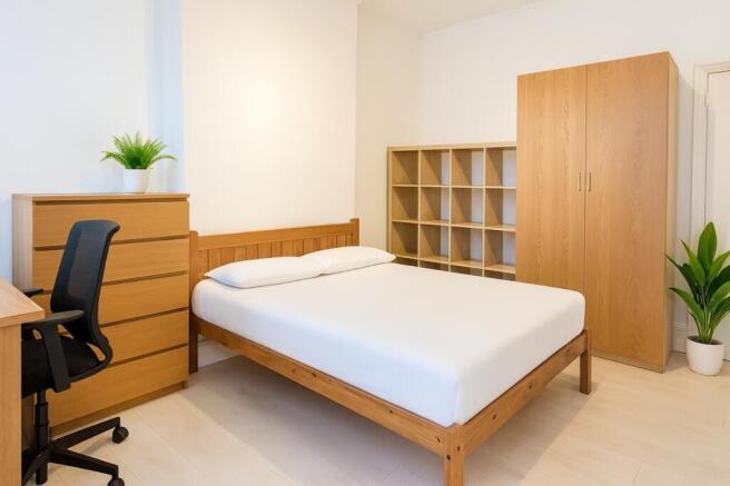 Bright, neatly furnished double bedroom with a ...
