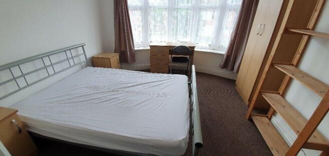 Bright master bedroom with large desk and stora...