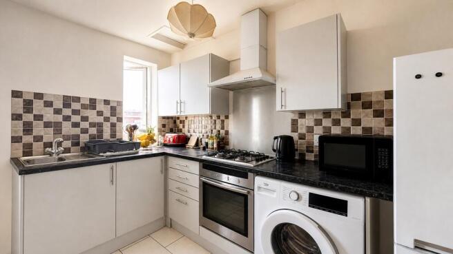Bright modern kitchen with integrated appliance...