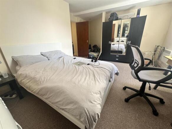 Spacious bedroom with double bed and desk area...